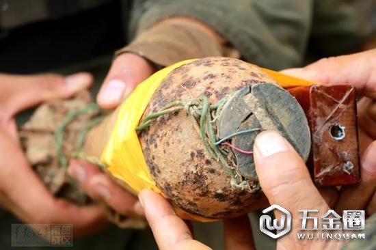 官兵正将炸药捆绑在一颗接有雷管的炮弹上