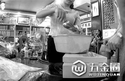 茶行工作人员将散装茶叶装袋
